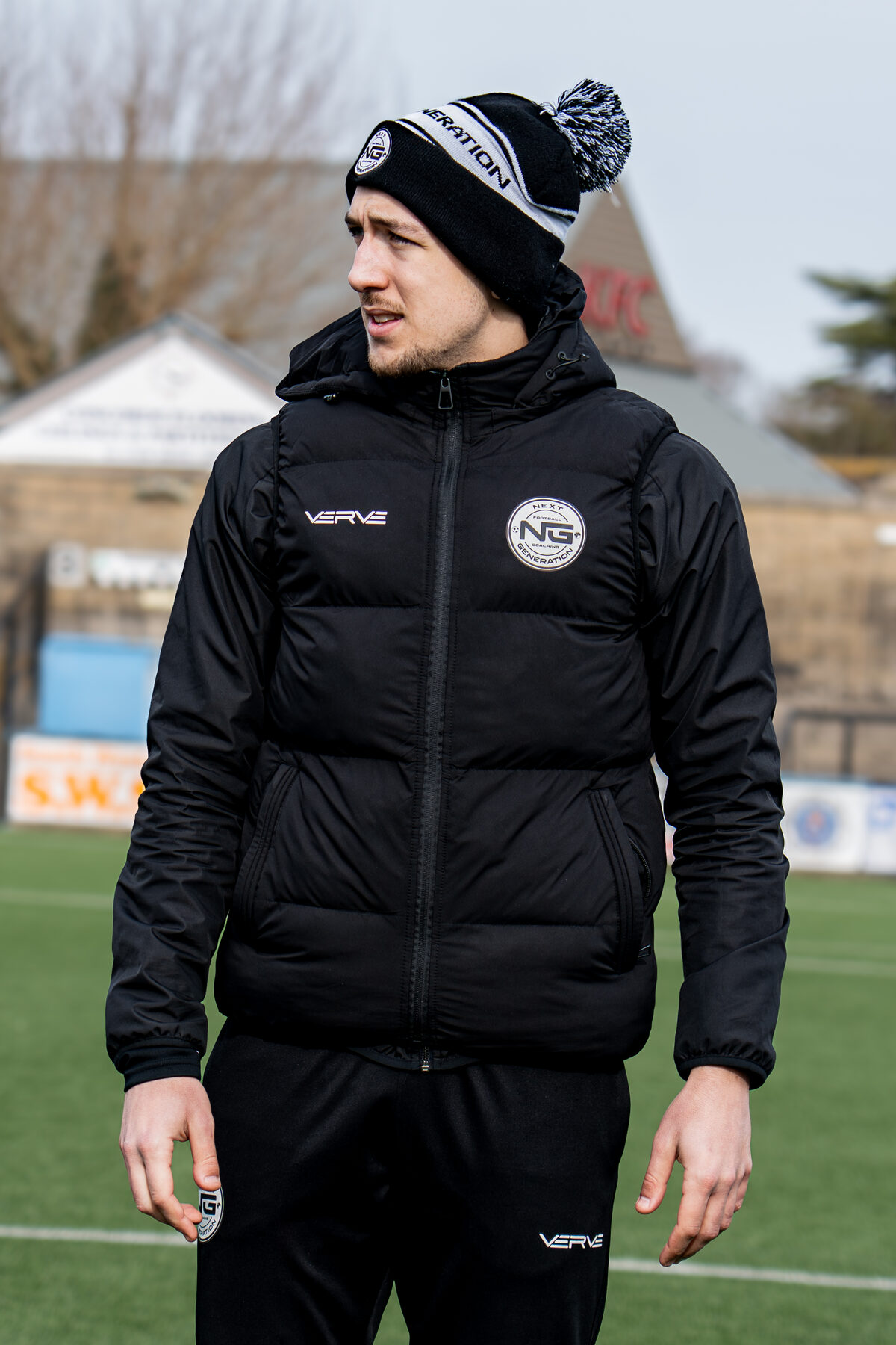 NGFC coach in branded jacket at the stadium