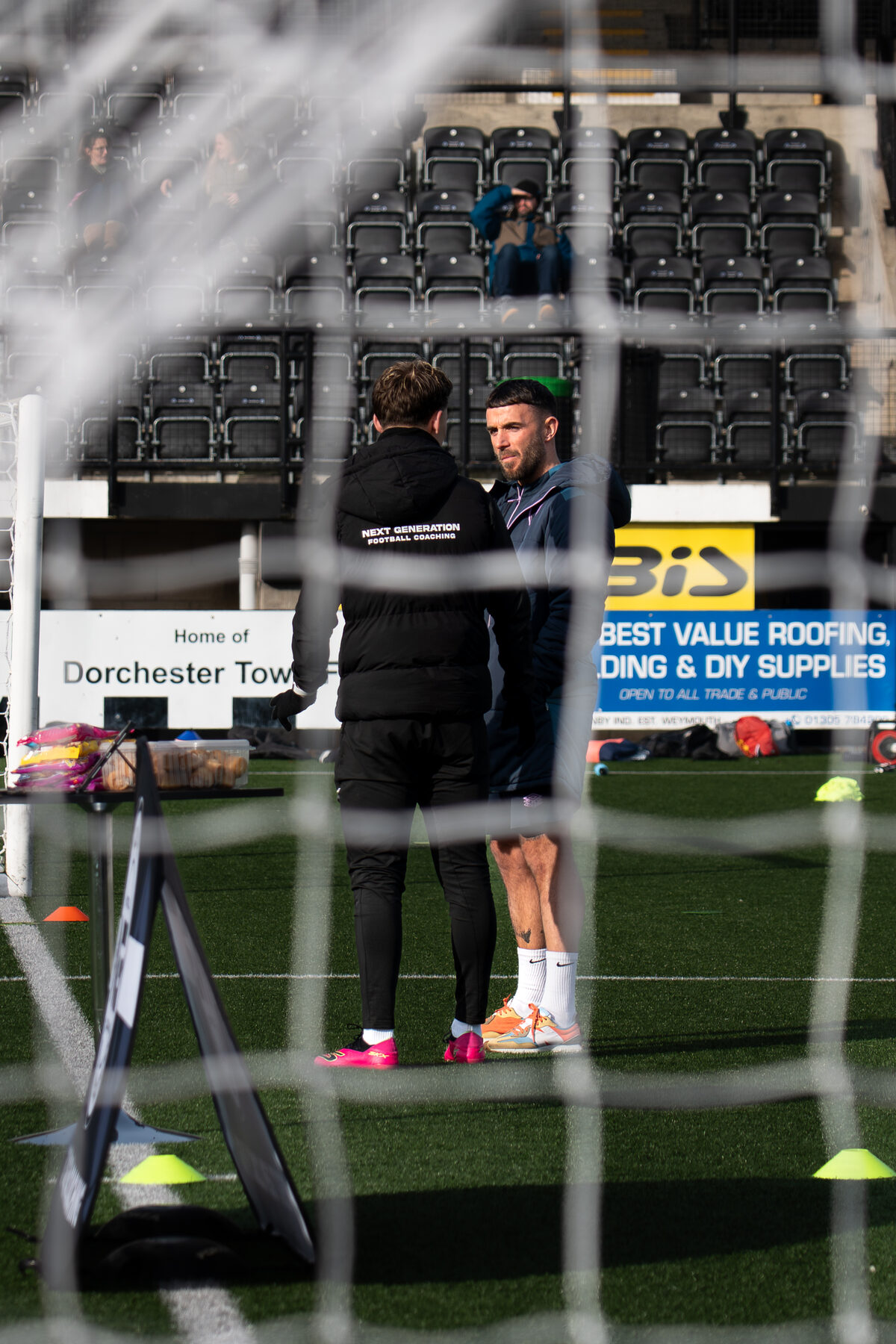Goalkeeper shot-stopping drill seen through the net