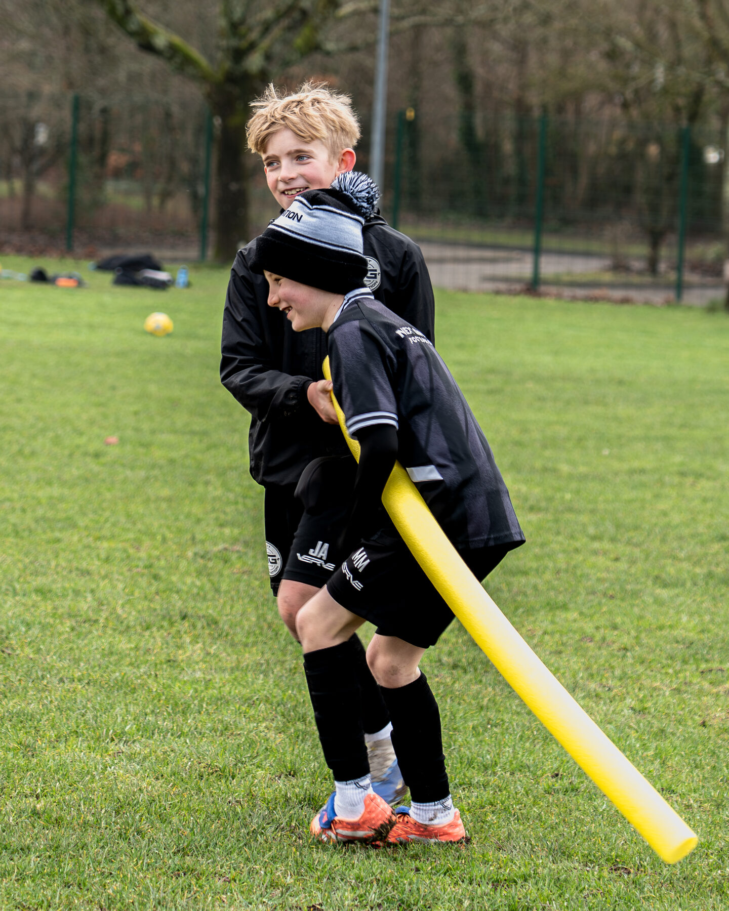 NGFC coach holding an agility hurdle as a player runs through