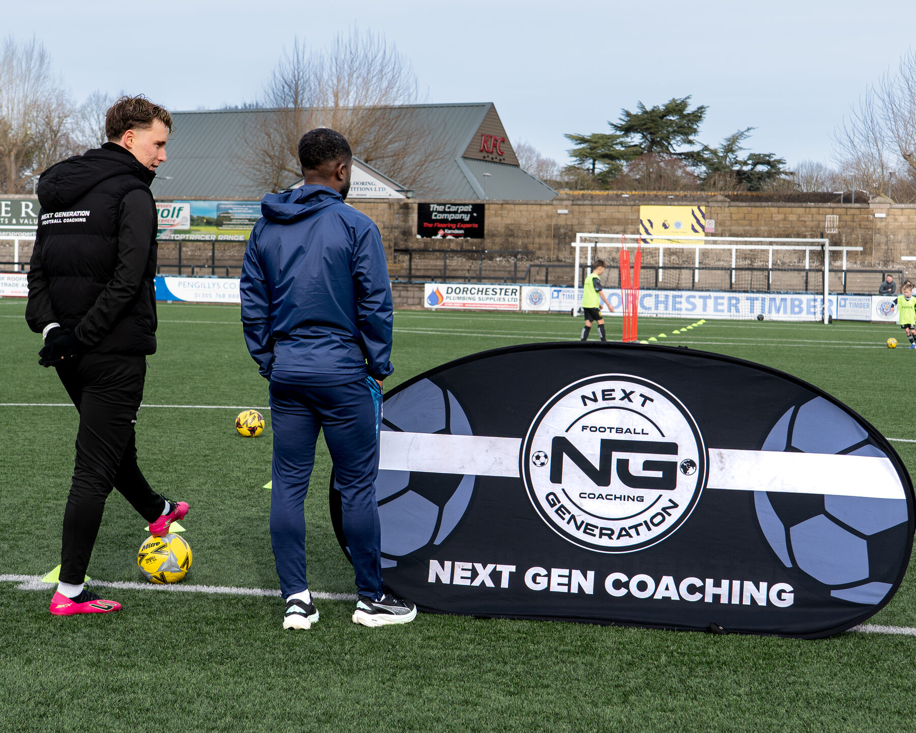 Player dribbling past the NGFC pitch-side banner