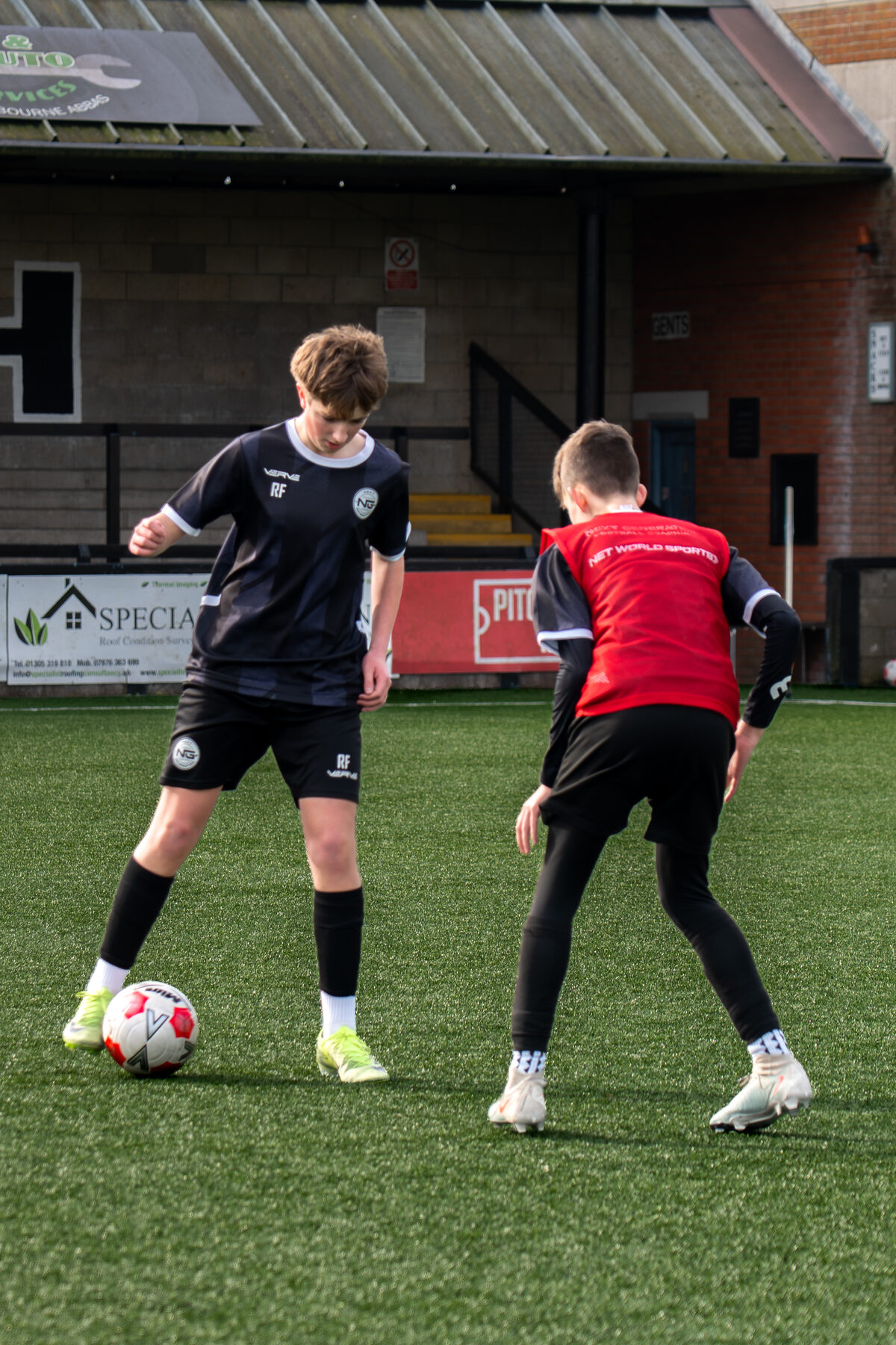Two young players battling for the ball in a small-sided game