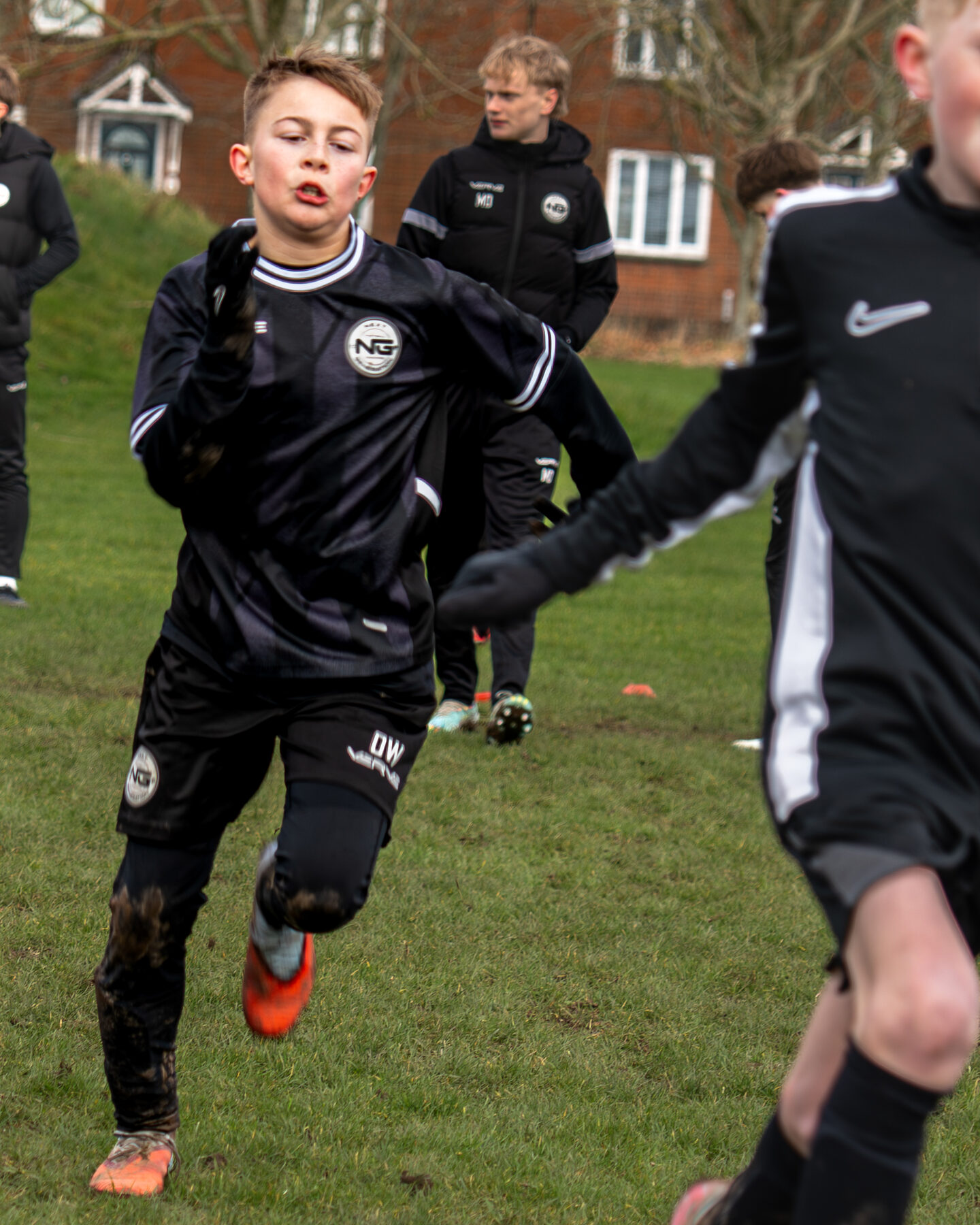 Player running with the ball across the training pitch