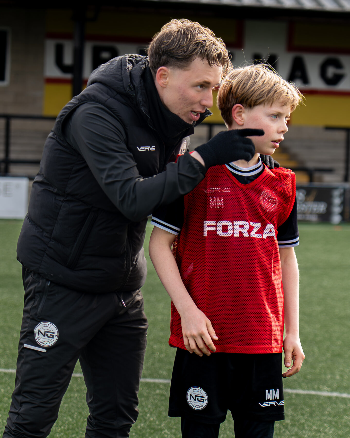 Coach giving individual technique feedback to a young player